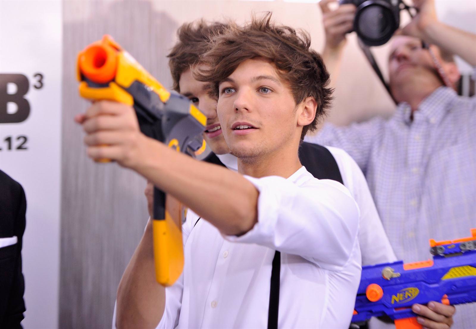 Louis Tomlinson, de One Direction, apunta con una pistola de juguete 