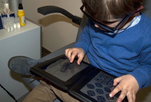 Niño realizando un Titmus test para explorar su visión en profundidad.