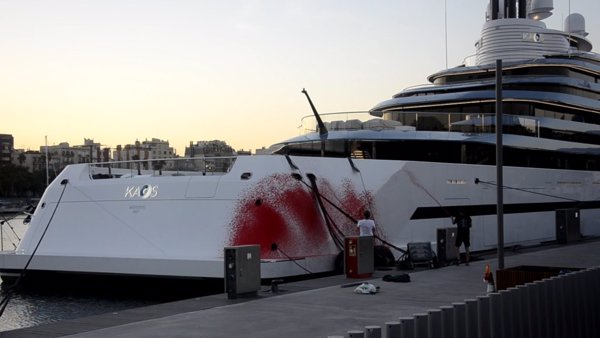 Activistas ecologistas pintan un barco en la Marina Port Vell de Barcelona