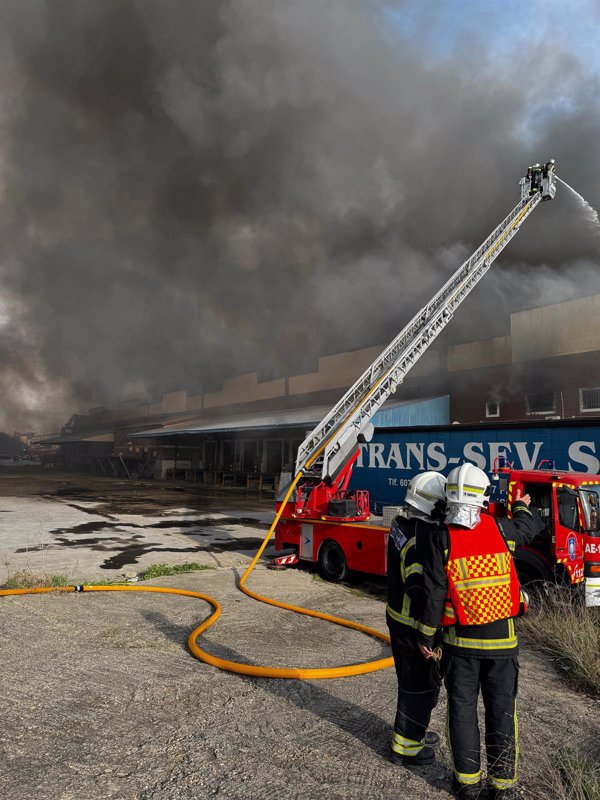 Perimetrado y casi controlado el gran incendio de toneladas de ropa de una nave en un polígono de Fuenlabrada (Madrid)