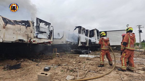 Bomberos trabajan para extinguir un incendio en una campa de Carlet (Valencia)