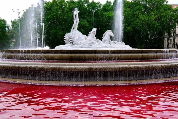 Activistas de Greenpeace tiñen de rojo el agua de la fuente de Neptuno para denunciar